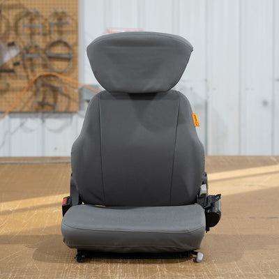 A TigerTough seat cover on a heavy equipment seat.  The back, bottom, and headrest are covered separately to give you the best possible fit.