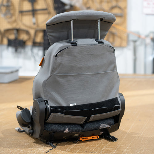 The back view of a heavy equipment seat with TigerTough seat covers. Cover has a built-in operating manual pocket.